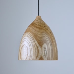 Puede incluir: Una taza de cerámica blanca con un asa negra y el texto "But First, Coffee" en negro, con una fuente de estilo manuscrito. La taza está sobre una superficie blanca.