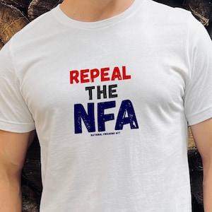 May include: White t-shirt with the text "Repeal the NFA" in red, blue, and black lettering. The text "National Firearms Act" is in smaller lettering below the main text.
