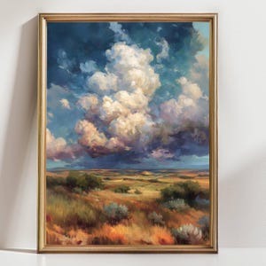 May include: An oil painting in a gold frame depicts a dramatic landscape. The sky is filled with large, fluffy white clouds against a backdrop of deep blue. The foreground shows a field of golden grass and green bushes.