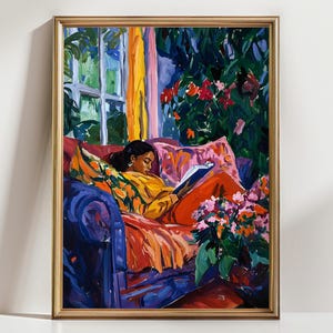 May include: A framed painting depicts a person reading on a blue sofa. The person wears a yellow top and orange pants. The background features a window, flowers, and colorful accents. The painting is in a gold frame.