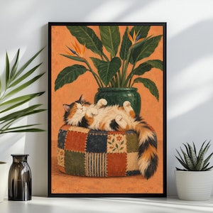 May include: A framed wall art print featuring a calico cat sleeping on a patchwork ottoman in front of a potted bird of paradise plant. The background is a solid orange color, and the cat has white, orange, and black fur with a fluffy tail.