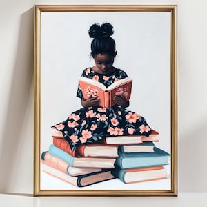 Op de afbeelding: Een ingelijste kunstdruk met een jong persoon die een boek leest terwijl hij op een stapel boeken zit. De persoon draagt een zwarte jurk met roze bloemmotieven. De boeken zijn in verschillende kleuren, waaronder rood, blauw en oranje. Het kunstwerk staat tegen een witte achtergrond.
