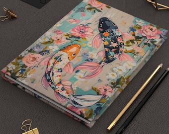 May include: A floral patterned notebook with two koi fish swimming in a blue and green water design. The fish are painted in bright colors with black, white, pink, orange, and blue details.