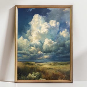 May include: A framed landscape painting shows a dramatic sky with large, fluffy white clouds against a deep blue backdrop. The foreground shows a field of tall, golden grass under a cloudy sky.