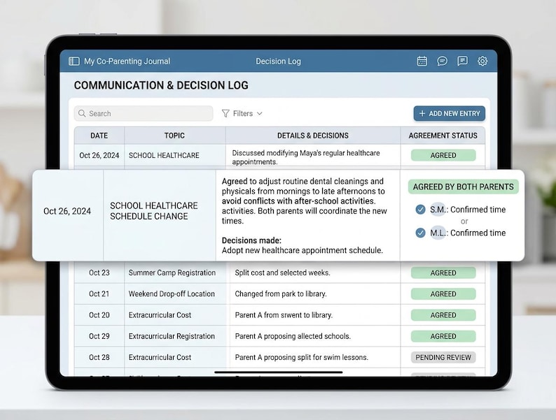May include: A digital tablet displaying a My Co-Parenting Journal app with a Communication & Decision Log table. The screen shows entries for dates, topics, details, and agreement status, including a pop-up window detailing a school healthcare schedule change.