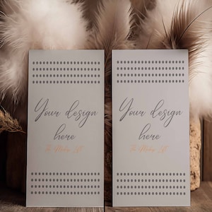 May include: Two blank white cards with a gray dotted pattern and the text "Your design here" and "The Maker Life" on a wooden surface with dried pampas grass and white feathers.