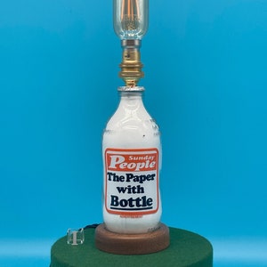 Eine Vintage Milchflasche aus den 1980er Jahren, die in eine elektrische 230V-Tischlampe (Unigate, COOP, Dairy Farm, Farmer, Kitchen, Breakfast) Zeitung
