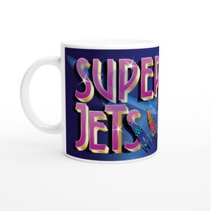 May include: White ceramic mug with the text "SUPER JETS" in purple and gold lettering on a dark blue backdrop. The mug also features illustrations of jets in red, blue, and yellow.