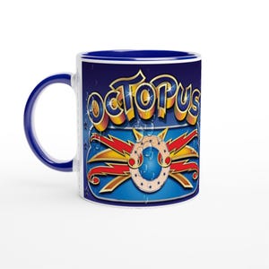 May include: A white ceramic mug with a blue handle and interior. The mug features the word "OCTOPUS" in a 3D gold and yellow font, with a blue and red design below. The design includes a ring with stars and water droplets.