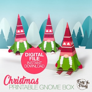 Puede incluir: Caja de gnomo de Navidad imprimible. Tres cajas de gnomo rojas y blancas con pantalones verdes y barbas blancas. Las cajas están sobre una superficie blanca con un fondo azul y verde. El texto "Archivo digital Descarga instantánea" está en un círculo rosa. El texto "Caja de gnomo de Navidad imprimible" está en letras grandes en la parte inferior de la imagen. El texto "Fácil y sencillo" está en un círculo con un par de tijeras.