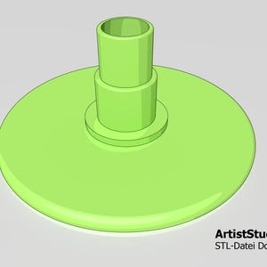 May include: A green plastic stand with a round base and a cylindrical top. The stand is designed to hold a small object, such as a pen or a pencil.