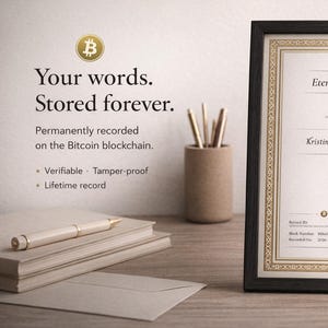 Op de afbeelding: Ingelijst "Eternity Certificate" met gouden accenten en een Bitcoin-logo. Het certificaat bevat de tekst "Kristin & Rudi 09.03.2019". De afbeelding toont ook een stapel boeken, een pen en potloden in een houder.
