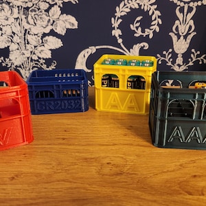 May include: Four different coloured plastic battery storage crates. The crates are labelled with the battery type: 9V, AAA, AA, and GR2032.