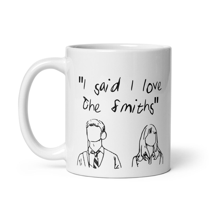 May include: White ceramic mug with a black line drawing of a man and woman. The mug has the text "I said I love the Smiths" printed on it.