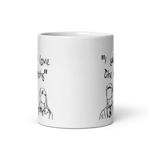 May include: White ceramic mug with black text and illustrations. The text reads "I love Smiths" and "I said the thing". The illustrations are of a woman and a man.