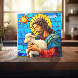 May include: Stained glass depiction of Jesus holding a white lamb in his arms. The background is a blue and yellow stained glass design.