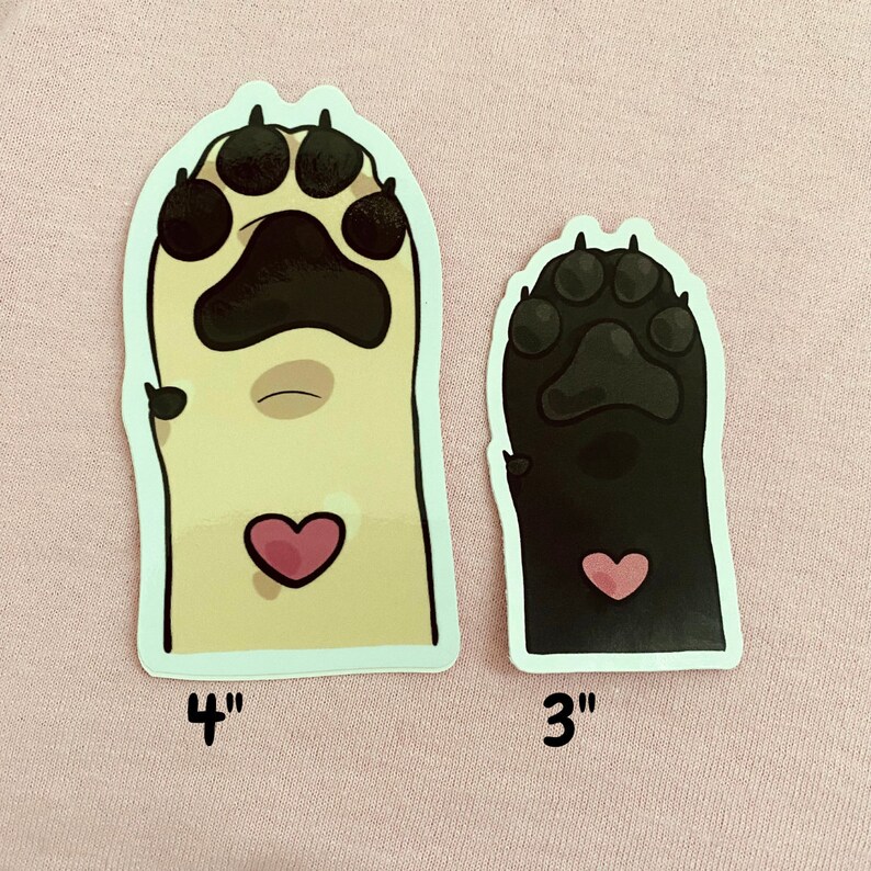 May include: Two paw print stickers, one is beige with a pink heart and measures 4 inches, the other is black with a pink heart and measures 3 inches.