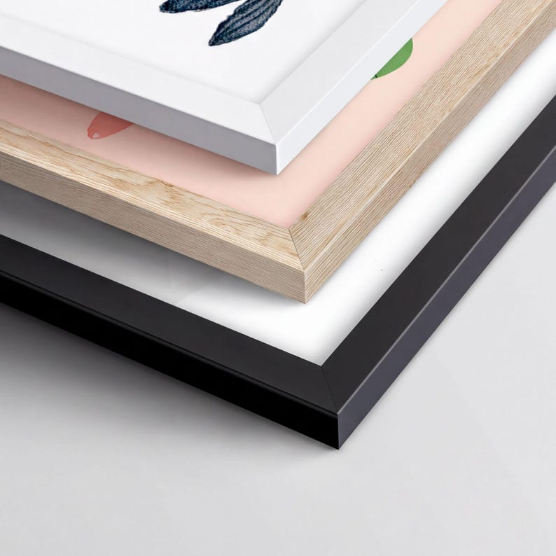 a close-up view of a stack of three framed artworks, each with a different color and frame style.