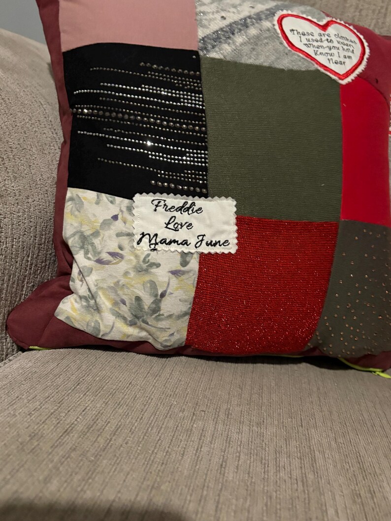 Pode incluir: Uma almofada de patchwork com quadrados de tecido em tons de vermelho, preto, verde e padr&otilde;es florais. A almofada apresenta o texto "Freddie Love Mama June" e um patch em forma de cora&ccedil;&atilde;o com texto.