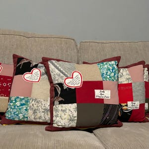 Pode incluir: Uma cole&ccedil;&atilde;o de almofadas decorativas de patchwork com bordas bord&ocirc;. Cada almofada apresenta uma combina&ccedil;&atilde;o &uacute;nica de quadrados de tecido em v&aacute;rias cores e padr&otilde;es, incluindo t&ecirc;xteis florais, lisos e estampados. Algumas almofadas t&ecirc;m apliques em forma de cora&ccedil;&atilde;o com texto.