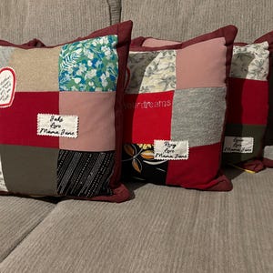 Pode incluir: Uma cole&ccedil;&atilde;o de almofadas de patchwork com bordas bord&ocirc;. Cada almofada apresenta uma combina&ccedil;&atilde;o &uacute;nica de tecidos em v&aacute;rias cores e padr&otilde;es, incluindo florais, lisos e texturizados. Algumas almofadas t&ecirc;m etiquetas bordadas e patches em forma de cora&ccedil;&atilde;o com texto.