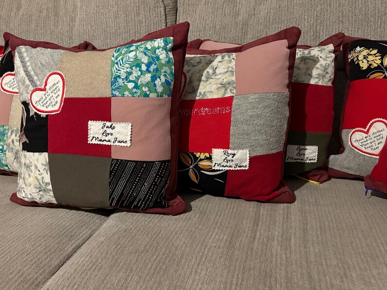 Pode incluir: Uma cole&ccedil;&atilde;o de almofadas de patchwork com bordas bord&ocirc;. Cada almofada apresenta uma combina&ccedil;&atilde;o &uacute;nica de tecidos em v&aacute;rias cores e padr&otilde;es, incluindo florais, lisos e texturizados. Algumas almofadas t&ecirc;m etiquetas bordadas e patches em forma de cora&ccedil;&atilde;o com texto.