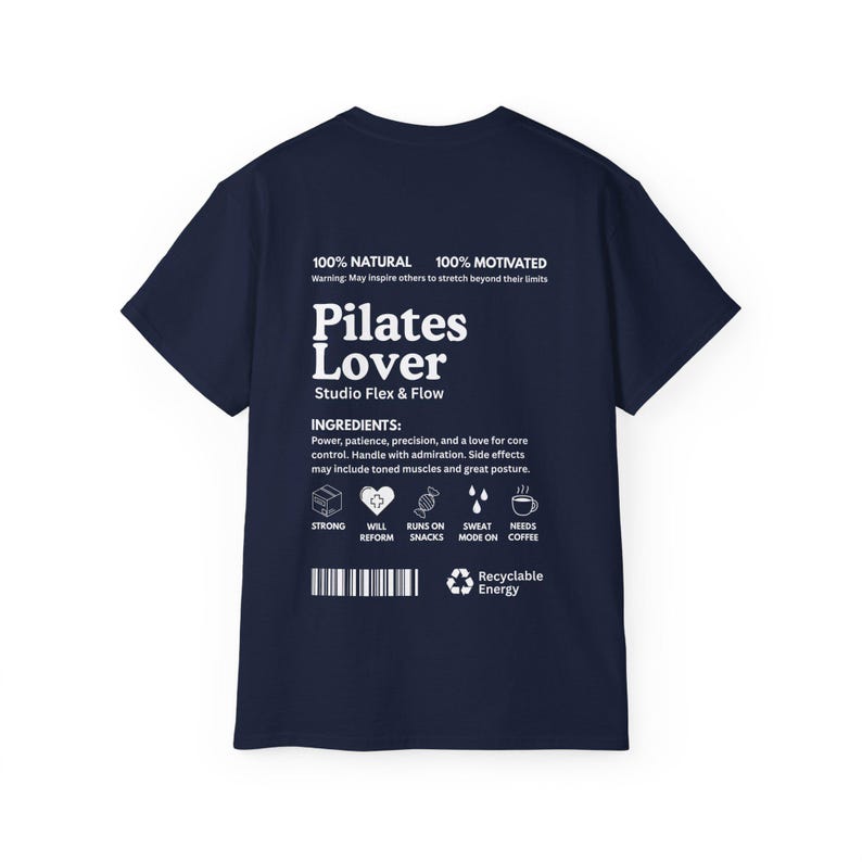 Puede incluir: Camiseta azul marino con texto blanco "Pilates Lover" y "Studio Flex & Flow". La camiseta tambi&eacute;n enumera "Ingredientes" e iconos. La camiseta est&aacute; hecha de un material suave.