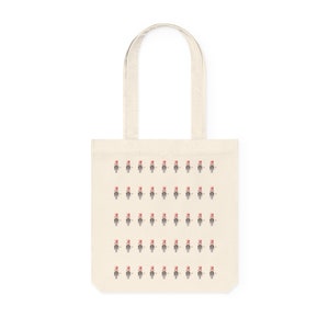 Könnte beinhalten: Eine weiße Einkaufstasche mit einem sich wiederholenden Muster einer pixeligen Figur, die einen roten Hut trägt. Die Figur ist schwarzweiß.