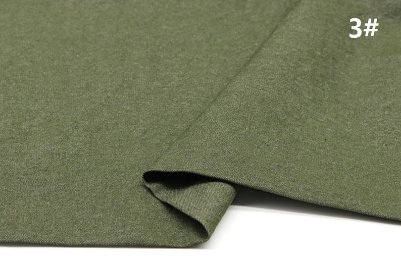 May include: A close-up of a piece of green fabric. The fabric has a textured surface and is folded in half. The number "3#" is written in white on the fabric.