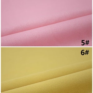 Pu&ograve; includere: Due campioni di tessuto, uno rosa e uno giallo, con una trama testurizzata. I campioni sono etichettati "5#" e "6#" rispettivamente.