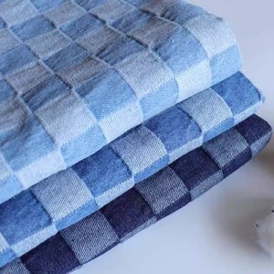 May include: Three layers of blue and white checked fabric, stacked on top of each other. The fabric is made of denim and has a soft, textured feel.
