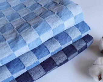 May include: Three layers of blue and white checked fabric, stacked on top of each other. The fabric is made of denim and has a soft, textured feel.