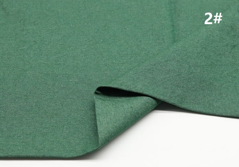 May include: A close-up of a dark green fabric with a textured surface. The fabric is folded in half, showing the inside of the fabric. The text "2#" is visible in the top right corner of the image.
