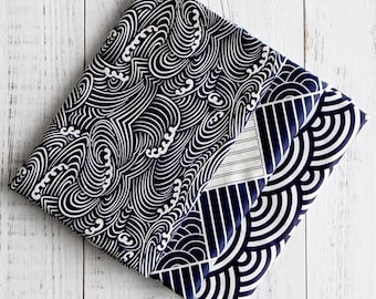 May include: Two pieces of fabric with a wave pattern in black and white. The fabric is folded in half and the wave pattern is visible on both sides.