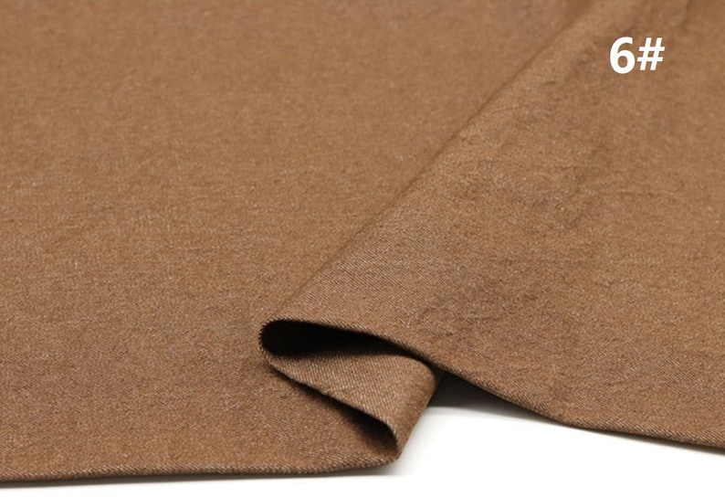 May include: Close-up of a brown fabric with a textured surface. The fabric is folded in half and the number "6#" is visible in the top right corner.