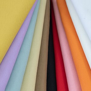 Pu&ograve; includere: Una collezione di campioni di tessuto in vari colori, tra cui giallo, viola, blu, beige, marrone, nero, rosso, rosa, arancione e bianco.