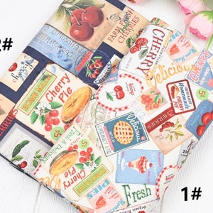 Könnte beinhalten: Ein weißer Stoff mit einem sich wiederholenden Muster aus Vintage-Stil-Illustrationen zum Thema Kirsche. Die Illustrationen zeigen Kirschen, Kirschkuchen und die Worte "Cherry Pie", "Farm Fresh Cherries", "Homemade Cherry Pie" und "Delicious".