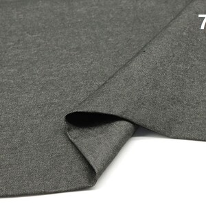 May include: A close-up of a dark grey fabric with a textured surface. The fabric is folded in half and the edges are visible. The number "7#" is printed in white on the fabric.