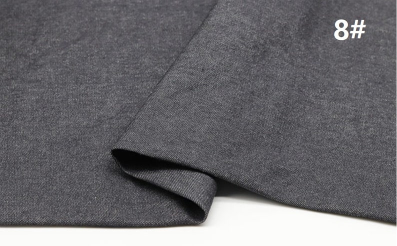 May include: Close-up of a dark grey fabric with a textured surface. The fabric is folded and the number 8# is visible in the top right corner.