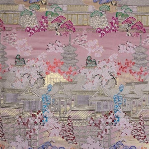 Peut inclure: Un tissu rose avec une scène de temple japonais en or et argent. Le tissu présente une pagode, des fleurs de cerisier et d'autres éléments japonais traditionnels.