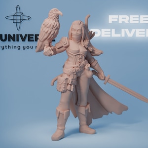 Op de afbeelding: Een miniatuurfiguur van een vrouwelijke krijger met een zwaard en een vogel die op haar arm zit. Ze draagt een leren outfit en een mantel. Het figuur is in lichtbruin geverfd.