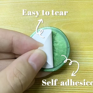 May include: A green self-adhesive sticker with a white backing. The sticker is easy to tear and peel off the backing.