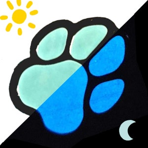 Op de afbeelding: Een poot afdruk ontwerp dat in het donker gloeit. De poot afdruk is zwart met een lichtblauwe kern. De poot afdruk gloeit helderblauw in het donker.