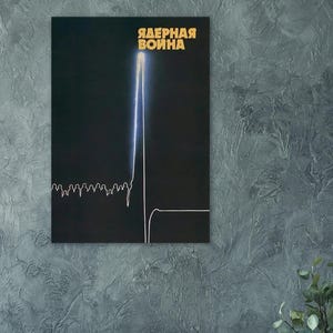 Könnte beinhalten: Ein schwarzes Poster mit dem russischen Text "ЯДЕРНАЯ ВОЙНА" in goldener Schrift. Eine weiße Strichzeichnung zeigt eine Stadtlandschaft und eine vertikale Linie mit blauem Leuchten. Das Poster ist an einer grau strukturierten Wand befestigt.
