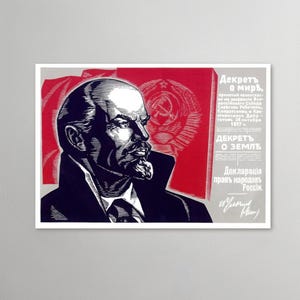 Könnte beinhalten: Ein gerahmtes Vintage-Poster mit einem schwarz-weißen Porträt eines Mannes im Profil, vor einem roten und grauen Hintergrund. Das Poster enthält kyrillischen Text und ein Hammer-und-Sichel-Emblem, was auf historische politische Propaganda hindeutet.