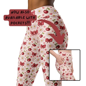 Op de afbeelding: Roze leggings met een kersen- en madeliefjesprint. De leggings hebben zakken aan de zijkanten. "NOW ALSO AVAILABLE WITH POCKETS!!!" staat op de afbeelding.