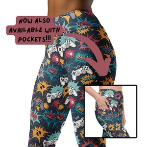 Può includere: Leggings neri con una stampa colorata di controller per videogiochi, esplosioni e parole come "Pow!" e "Couch." I leggings hanno tasche. Il testo "NOW ALSO AVAILABLE WITH POCKETS!!!" è scritto in un riquadro bianco sull'immagine.
