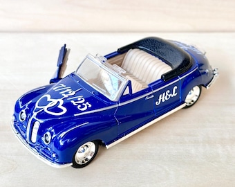 May include: Blue toy car with a white heart and the text "1925" and "H&L" on the side.