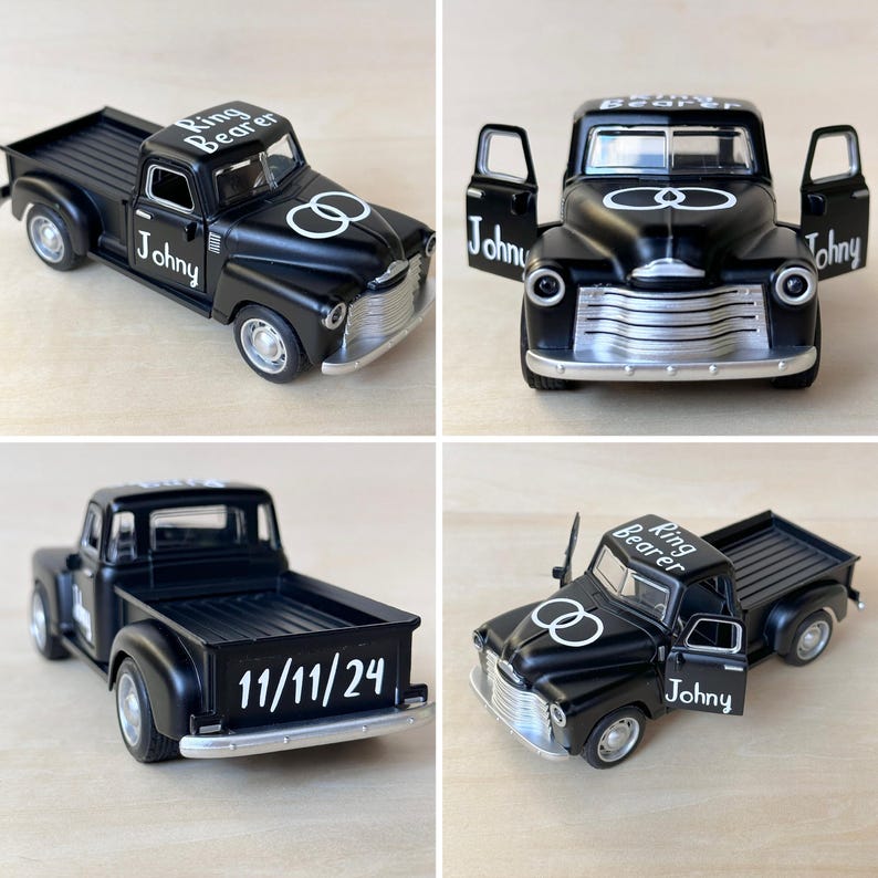 May include: Black toy pickup truck with white lettering that says "Ring Bearer" and "Johnny". The truck has two silver rings on the side and the date "11/11/24" on the back.
