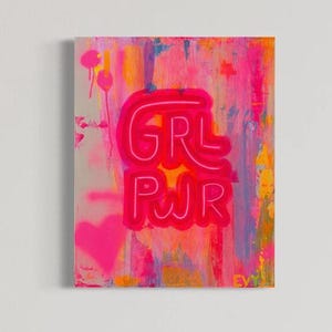 May include: Abstract painting with the words "GRL PWR" in bright pink neon lettering. The background features a blend of pink, orange, and yellow hues with paint drips and a pink heart. The artwork is signed "EVY" in the bottom right corner.